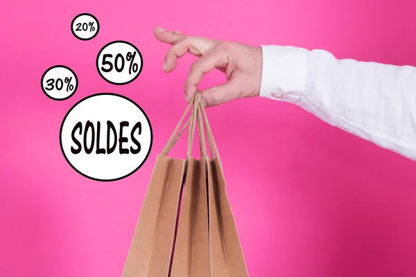 man with bags in hand with sale and discounts text, concept of shopping and sales