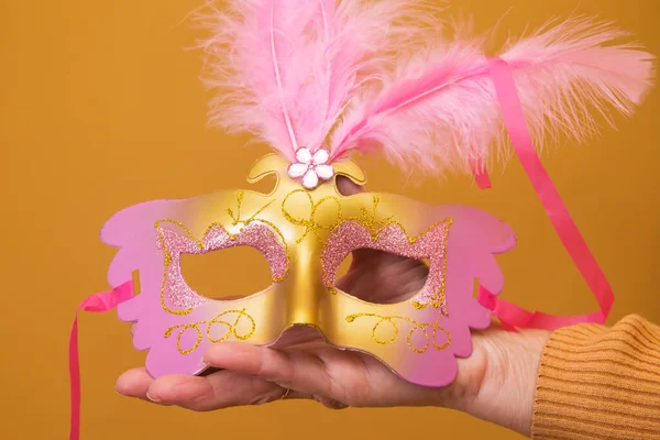 hand holding carnival mask with background, happy carnival day