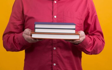 Elinde kitaplar olan bir adam.