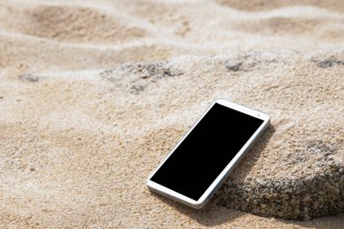 mobile phone in the sand on the beach