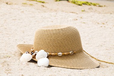Plajda şapka ve deniz kabukları, yaz tatili konsepti.