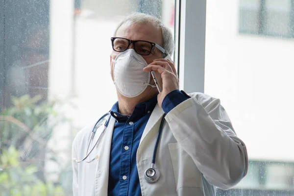 doctor with mask using mobile phone