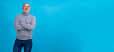 Yakışıklı, orta yaşlı, mutlu yüzlü, kendine güvenen, gülümseyen bir adam.