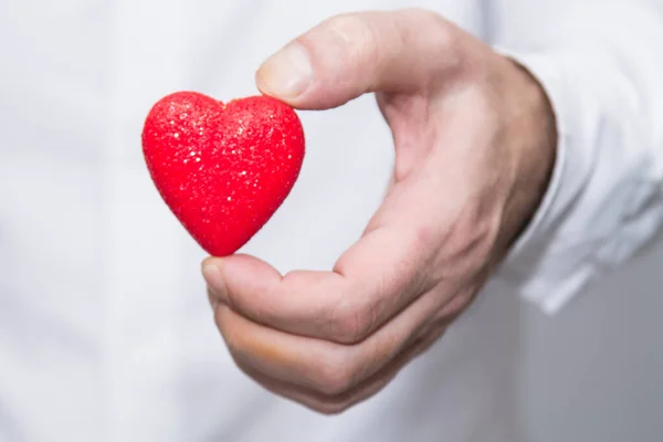 Hand Giving Bright Red Heart — Stock Photo, Image
