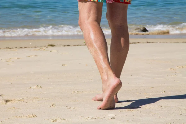male feet on beach