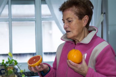Greyfurt ve portakal tutan yaşlı kadın, diyet ve sağlık konsepti