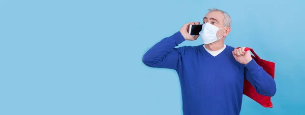 Mężczyzna Maską Chirurgiczną Pomocą Telefonu Komórkowego Torby Koncepcji Zakupów Online — Zdjęcie stockowe