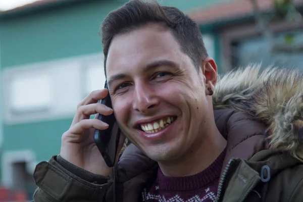 smiling man using mobile phone on the street