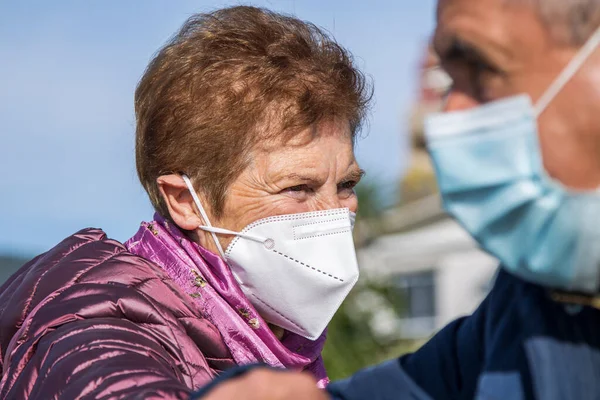 two elderly people wearing face mask and greeting safely during covid-19 or coronavirus outbreak to prevent infection. social distancing and new lifestyle concept