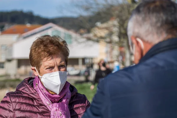 Two senior people wearing a mask are on the street keeping a safe distance during the outbreak of covid-19 or coronavirus to prevent infection. social distancing and new lifestyle concept