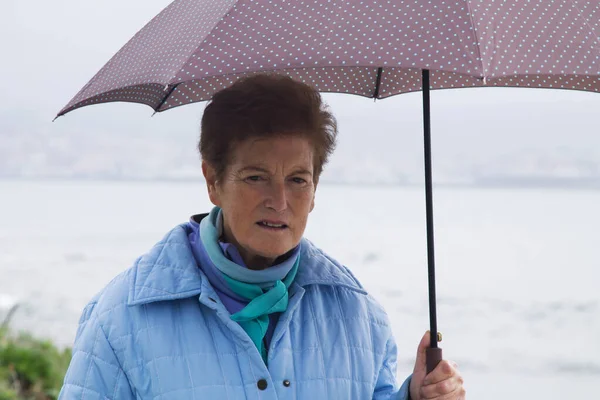 Seniorin Mit Mantel Und Regenschirm Vor Der Küste — Stockfoto