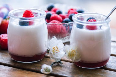 ahududulu yoğurt ve ahşap arka planda yaban mersini.