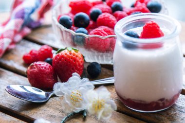 ahududulu yoğurt ve ahşap arka planda yaban mersini.