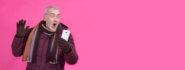 Şaşırmış yüz ifadesi olan bir adam cep telefonu kullanıyor.