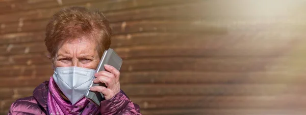 Ηλικιωμένη Γυναίκα Που Χρησιμοποιεί Κινητό Τηλέφωνο Μάσκα Και Αναλώσιμα Ιατρικά — Φωτογραφία Αρχείου