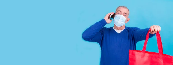 Mężczyzna Maską Chirurgiczną Pomocą Telefonu Komórkowego Torby Koncepcji Zakupów Online — Zdjęcie stockowe