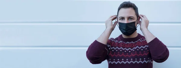 young man with medical mask on his face protecting himself against viruses and infections