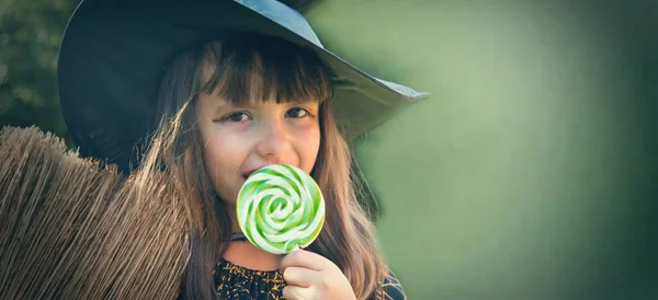 witch eating a candy lollipop, halloween party