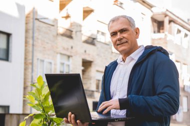 dizüstü bilgisayar kullanan çekici yaşlı adam