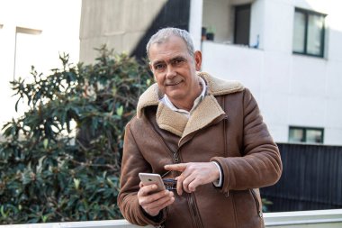 Yetişkin bir adam telefonu kullanıyor.