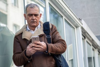 Yetişkin yakışıklı iş adamı telefon kullanıyor.