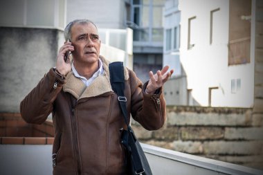 İş adamı cep telefonuyla konuşuyor.