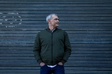 Orta yaşlı adam kör geçmişiyle gülümsüyor.