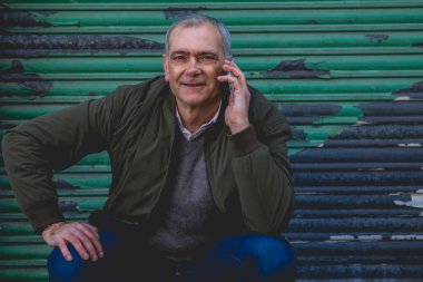 Sıradan bir yetişkin adam kör geçmişiyle cep telefonuyla konuşuyor.