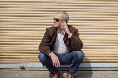 Yetişkin bir adam şehirde cep telefonu kullanıyor.