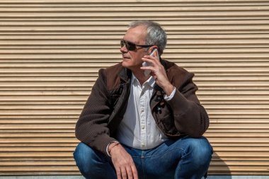 Yetişkin bir adam şehirde cep telefonu kullanıyor.