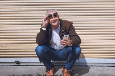 Yetişkin bir adam şehirde cep telefonu kullanıyor.