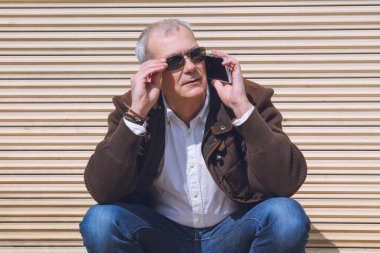 Yetişkin bir adam şehirde cep telefonu kullanıyor.