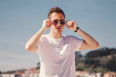 man with sunglasses walking on the beach