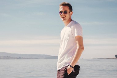 man with sunglasses walking on the beach