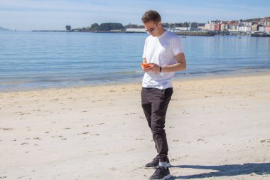 handsome man using mobile phone on the beach