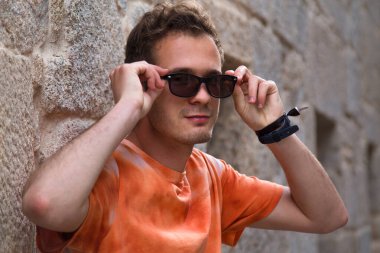 portrait of man with sunglasses on stone wall