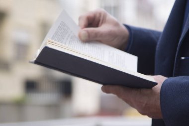 İş adamı ofiste kitap okuyor.