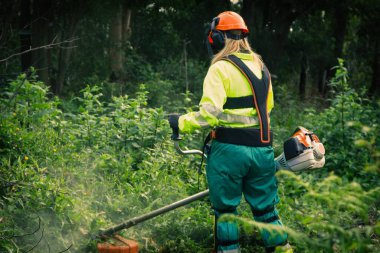 Forestry worker cutting the grass
