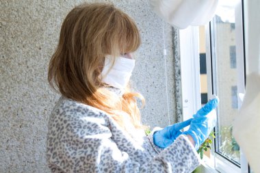 woman using mobile phone with mask and medical protective gloves for health protection and prevention of influenza virus, epidemics and infectious diseases