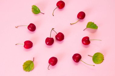 Pembe arka planda kırmızı kirazlar