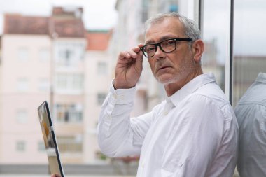 dizüstü bilgisayar kullanan gözlüklü olgun bir adam