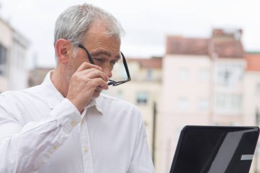 mature man using laptop computer close up view