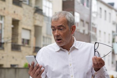 Cep telefonu kullanarak sürpriz jest yapan son sınıf öğrencisi.