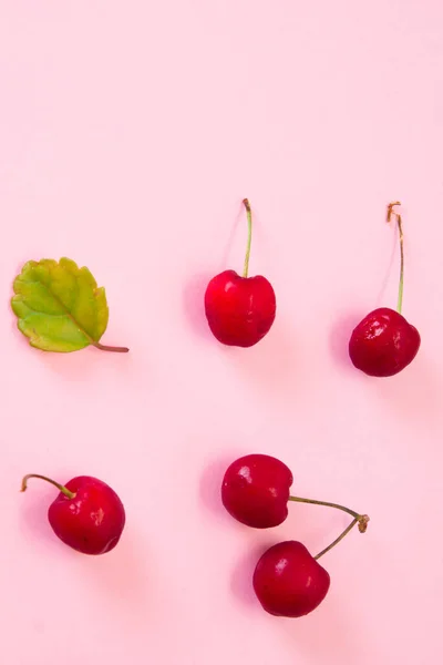 Rote Kirschen Auf Rosa Hintergrund — Stockfoto