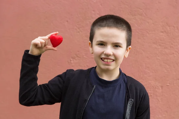 手に癌と赤の心臓を持つ少女は — ストック写真