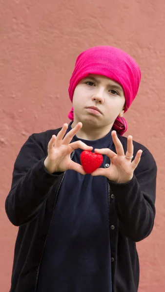 癌の悲しい女の子と赤いハートを持った頭のスカーフ — ストック写真