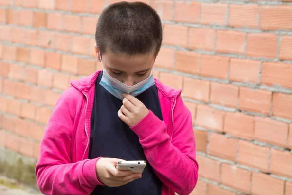 girl with medical mask using mobile phone