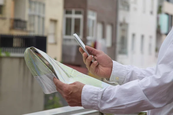 man with a world map in hand and mobile phone in the other, travel and vacation concept