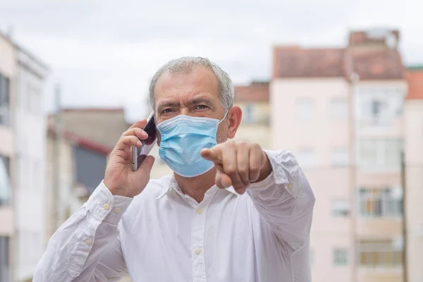 Hombre Con Máscara Médica Hablando Con Teléfono Móvil Señalando Con — Foto de Stock