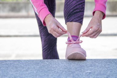woman tying sneakers on the street